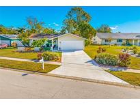 Attractive single-story home with a large driveway and well-maintained lawn at 12136 Kay Dr, Seminole, FL 33772