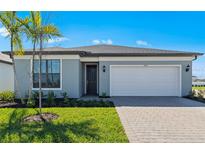 Charming single-story home with a well-manicured lawn and a two-car garage at 2748 Winding Creek Trl, North Port, FL 34289