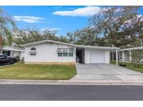 White single-story home with carport and mature landscaping at 34124 Estates Ln, Wesley Chapel, FL 33543
