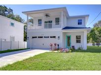Two-story house with balcony, attached garage, and landscaped lawn at 515 Elm St, Safety Harbor, FL 34695