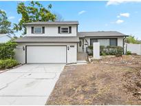 Attractive two-story home with a garage, a white exterior, and a landscaped front yard at 1601 Spring Ln, Brandon, FL 33510