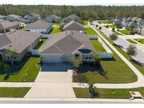 Expansive aerial view of a single-Gathering home with a well-manicured lawn and white fenced-in backyard at 12512 Brick Cobblestone Dr, Riverview, FL 33579