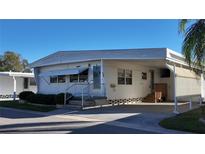 Charming single-story home featuring well-maintained landscaping and a convenient covered parking area at 2331 Belleair Rd # 611, Clearwater, FL 33764
