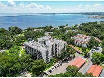 Aerial view of waterfront condo community with lush landscaping and parking at 2699 Seville Blvd # 605, Clearwater, FL 33764