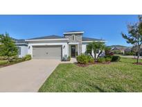 Single-story home with gray siding, stone accents, and a two-car garage at 7124 Estero Ct, Apollo Beach, FL 33572