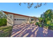 Brick ranch home with attached garage and landscaped yard at 2414 Locksley St, Sun City Center, FL 33573