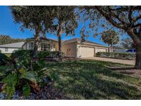 Charming home featuring a well-maintained lawn, mature trees and a two-car garage at 29417 Caddyshack Ln, San Antonio, FL 33576