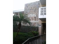 Exterior view of building 700 at 4910 Bay St NE, showing stone facade and landscaping at 4910 Bay Ne St # 309, St Petersburg, FL 33703