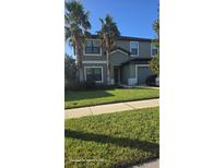 Two-story house with a green lawn and palm trees at 14207 Alistar Manor Dr, Wimauma, FL 33598
