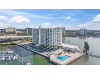 Aerial view of a waterfront high-rise building with a pool, marina, and city views at 100 Pierce St # 1210, Clearwater, FL 33756