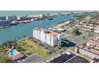Aerial view of waterfront community, showing building, pool, tennis court, and waterway at 10216 Regal Dr # 603, Largo, FL 33774