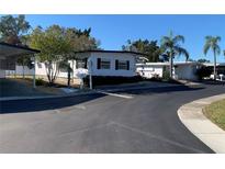 Charming single-story home with a carport, lush landscaping, and a well-manicured lawn at 3301 Alt 19 # 409, Palm Harbor, FL 34683