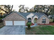 Brick house with a three-car garage and landscaped lawn at 3515 Buckboard Ln, Brandon, FL 33511