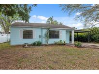 Quaint single-story home featuring light blue siding, white trim, and a covered carport at 3918 W Fig St, Tampa, FL 33609