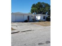 Ranch style home with a single car garage and mature landscaping at 1147 Viking Dr, Holiday, FL 34691