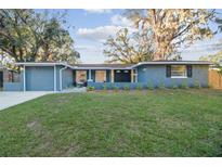 Newly renovated, light blue single story home with a spacious lawn and attached garage at 7804 N Whittier St, Tampa, FL 33617