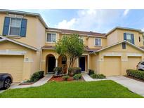 Front view of two-story townhouses with attached garages and landscaping at 10817 Great Carlisle Ct, Riverview, FL 33578
