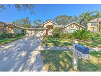 Single-story house with red door, two-car garage, and well-manicured lawn at 3125 Bent Creek Dr, Valrico, FL 33596