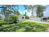 Charming single-story home featuring a well-maintained lawn and a driveway leading to a detached garage at 3562 Fisher Rd, Palm Harbor, FL 34683