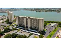 Aerial view of a waterfront high-rise building with parking and lush landscaping at 7050 Sunset S Dr # 405, South Pasadena, FL 33707