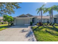 Exterior view of charming villa with attached garage and landscaped lawn at 1257 Corinth Greens Dr # 1257, Sun City Center, FL 33573