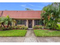 Condo exterior featuring Spanish tile roof and landscaping at 19029 Us Highway 19 N # 13F, Clearwater, FL 33764