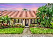 Charming single-story home with a tile roof, complemented by lush tropical landscaping and a well-manicured lawn at 19029 Us Highway 19 N # 13F, Clearwater, FL 33764