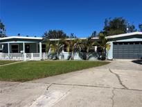 Light blue single story home with a large yard and two car garage at 205 81St Ne Ave, St Petersburg, FL 33702