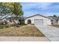 Single-story home with attached garage and well-maintained lawn at 2240 Colonial Dr, Dunedin, FL 34698