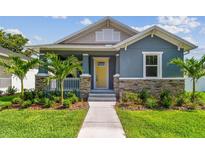 Charming blue single-story home with a welcoming yellow front door, stone accents, and a beautifully landscaped yard at 2729 36Th N Ave, St Petersburg, FL 33713