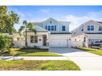 Two-story light blue house with a white garage door and landscaping at 1820 47Th N Ave, St Petersburg, FL 33714