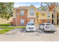 Brick and yellow-sided condo building with parking and landscaping at 8722 Mallard Reserve Dr # 204, Tampa, FL 33614