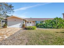 Single-story house with attached garage and well-maintained lawn at 219 Leeward Is, Clearwater Beach, FL 33767