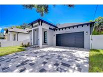 Modern house exterior with gray and white paved driveway and a two-car garage at 2308 1/2 Saint Louis, Tampa, FL 33607