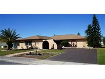Single-story home with a large driveway and landscaped yard at 1727 Coco Palm Cir, Sun City Center, FL 33573