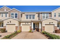 Three-unit townhome building with two-car garages and attractive landscaping at 18843 Ulmus St, Lutz, FL 33558