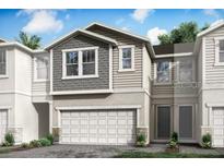 Two-story home with gray and beige siding, white garage door, and landscaping at 26024 Fantasy Sky Ln, Lutz, FL 33559