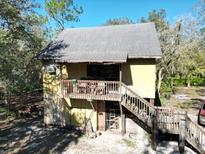 Elevated home with wooden stairs and deck, offering a unique style at 39716 Tworut Rd, Webster, FL 33597