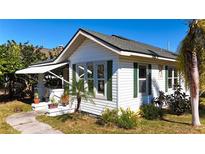 White house with green shutters, awning, and landscaped yard at 6715 32Nd N St, St Petersburg, FL 33702