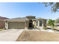 Single-story house with a two-car garage and well-maintained landscaping at 8601 Sandy Plains Dr, Riverview, FL 33578