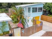 Cute two-story light blue house with a mural, American flag, and fenced yard at 4801 14Th S Ave, St Petersburg, FL 33711