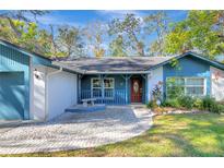 Inviting home exterior with a blue facade, charming porch, and well-maintained landscaping at 14912 Northwood Village Ln, Tampa, FL 33613