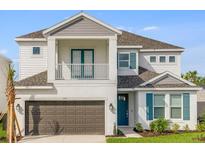 Charming two-story home featuring a balcony, a front-facing garage, and attractive architectural details at 1979 Longliner Loop, Wesley Chapel, FL 33543