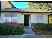 Inviting condo exterior featuring a private entrance and well-manicured landscaping at 2440 Enterprise Rd # 4, Clearwater, FL 33763