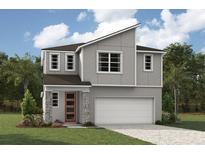 Two-story modern home with gray siding, stone accents, and a two-car garage at 31272 Pendleton Landing Cir, Wesley Chapel, FL 33545