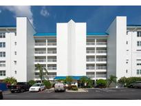 Three-story building with blue roof and ample parking at 9359 Blind Pass Rd # 205, St Pete Beach, FL 33706