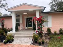 Pink brick house with white columns, green door, and lush landscaping at 200 Carmona Ne Way, St Petersburg, FL 33704