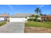 Cute yellow house with a large driveway and well-maintained lawn at 4603 Topsail Trl, New Port Richey, FL 34652