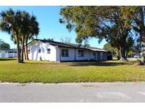 White single story home with a large front yard and mature trees at 212 Francis Dr, Apollo Beach, FL 33572