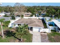 Aerial view of a single-story home with a fenced yard and palm trees at 2463 Baywood E Dr, Dunedin, FL 34698